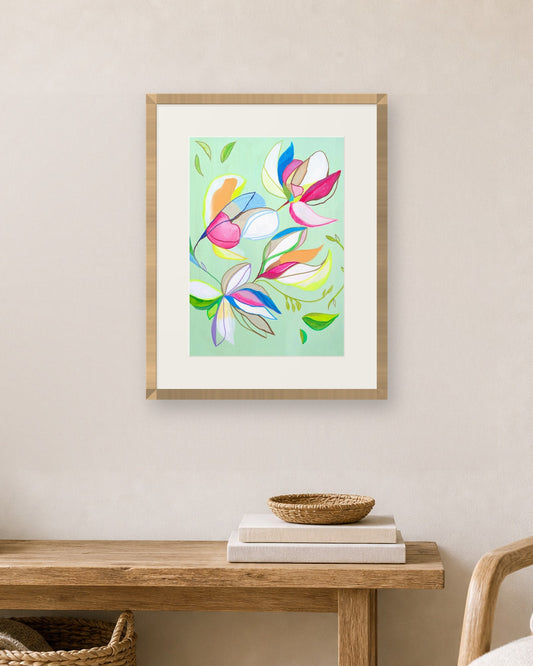 Falling Magnolias by Amber Miro, fine art print shown in a natural oak frame with a white mat (frame not included)