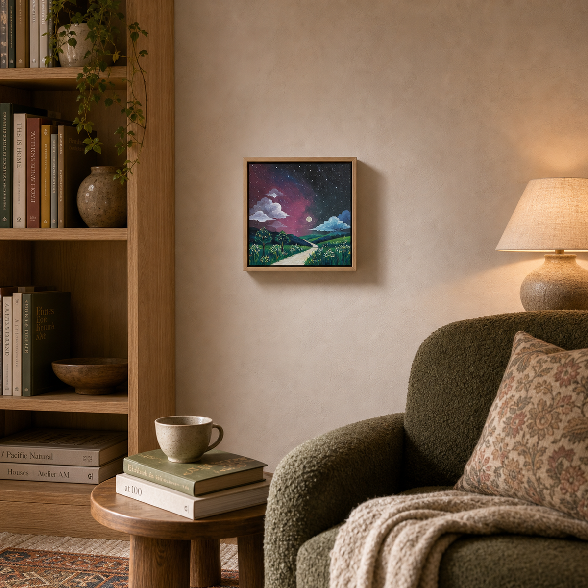 Aurora by Amber Miro, original night sky painting in pink, violet, and green, on the wall by a bookshelf and armchair