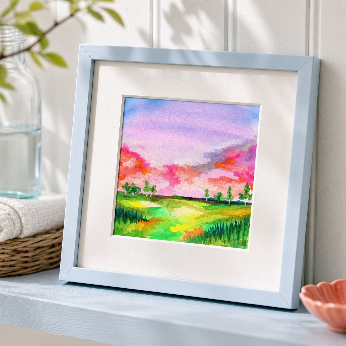 Field by Amber Miro, original watercolor of an open field under a soft sky, angled view in a pale blue frame with white mat