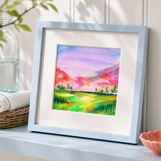 Field by Amber Miro, original watercolor of an open field under a soft sky, angled view in a pale blue frame with white mat