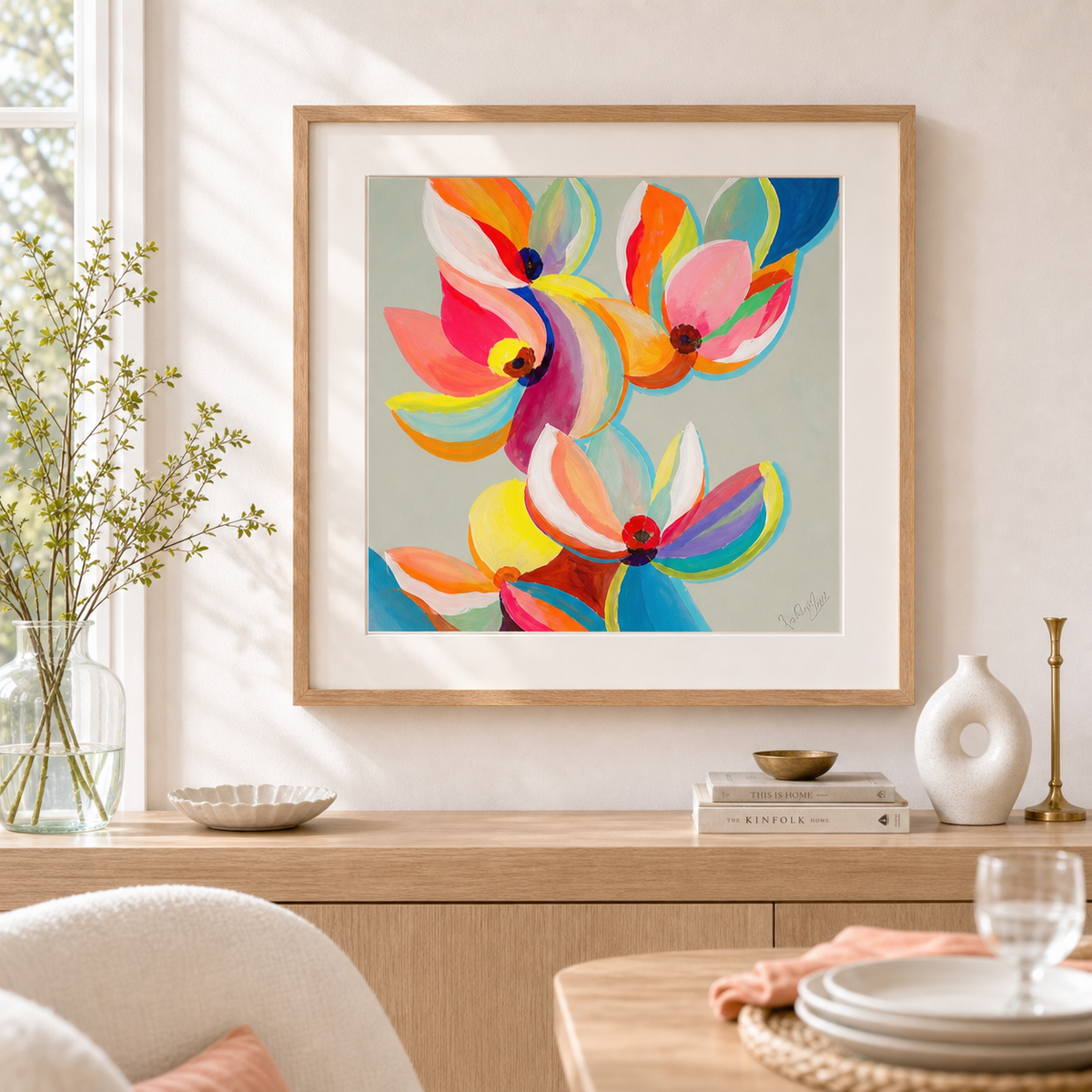 Magnolia Colors by Amber Miro, original magnolia painting in orange and magenta, framed above a sideboard in a dining area