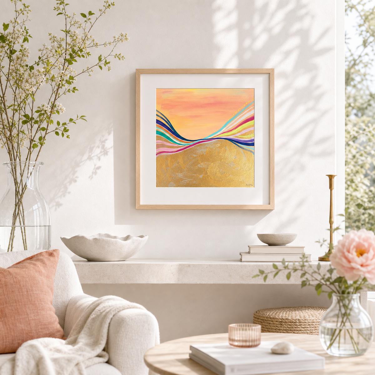 Pink Electric by Amber Miro, original sunset painting in coral, gold, and hot pink, framed above a shelf in a living room